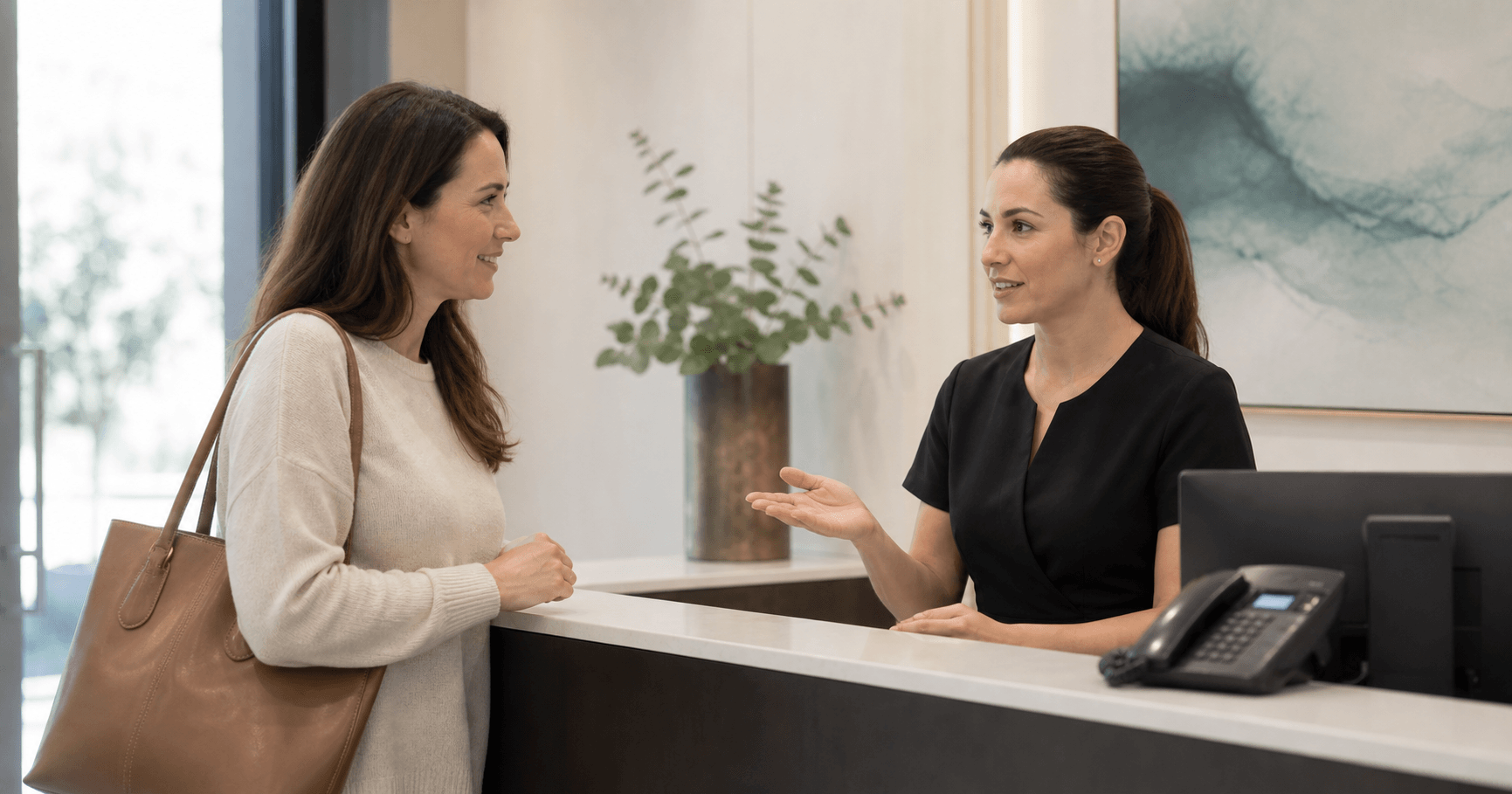 Profesional de recepción dando la bienvenida a una paciente en una clínica dental